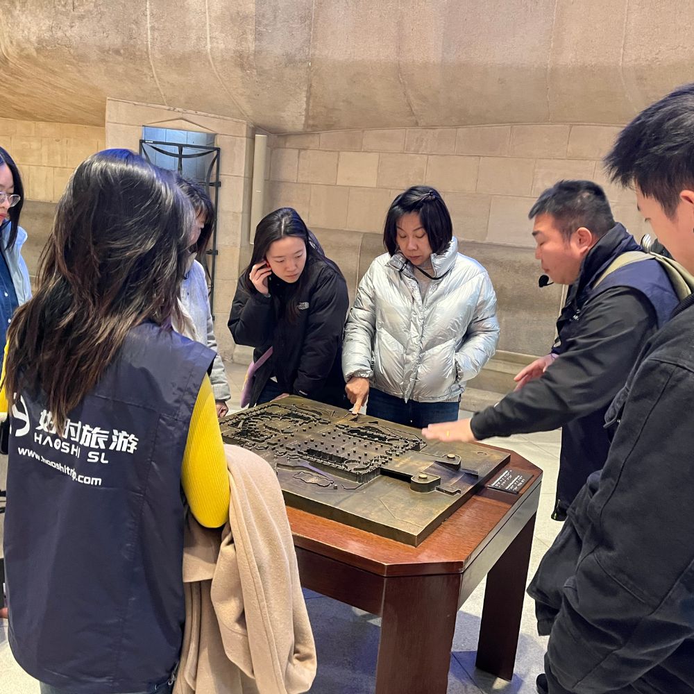 Visitors learning about a Sagrada Familia architectural model during a Chinese guided tour